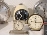 many different types of clocks displayed on a table