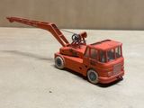 un camion jouet rouge équipé d'une grue à l'arrière