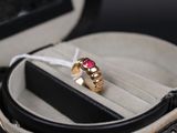 une bague en or sertie d'une pierre rose, dans un écrin