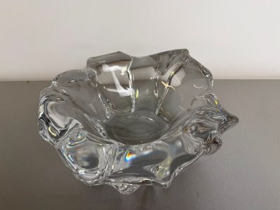 a glass bowl on a table with a white wall in the background