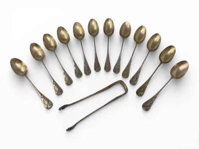 six spoons and a spoon rest in a circle on a white surface
