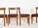 three wooden chairs sitting next to each other on a white surface