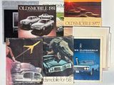 tout un tas de brochures de voitures anciennes posées sur une table
