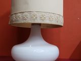 une lampe posée sur une table recouverte d'une nappe rouge