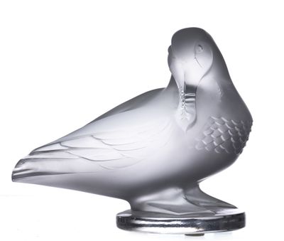 une sculpture en verre représentant un oiseau posé sur un socle