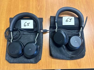 two black headphones sitting on top of a table next to each other