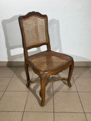 a wooden chair that is sitting on a tile floor