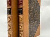 deux vieux livres posés l'un sur l'autre sur une surface blanche