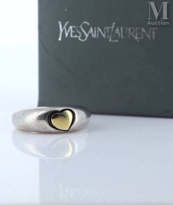 silver and gold heart ring in front of a box of jewelry