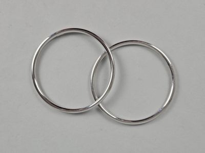 two silver rings on a white surface with a white background