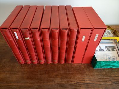 six livres rouges posés les uns à côté des autres sur une table en bois
