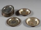 quatre assiettes en métal argenté et un saladier en verre posés sur une table
