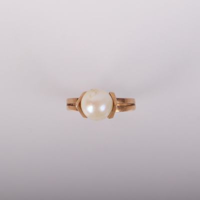une bague en or avec une perle au centre