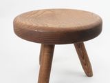 a small wooden stool with three legs on a white background
