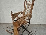 a small child ' s stroller made out of wood and wicker