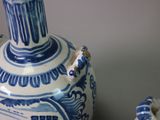 a blue and white vase sitting on a table next to a mirror