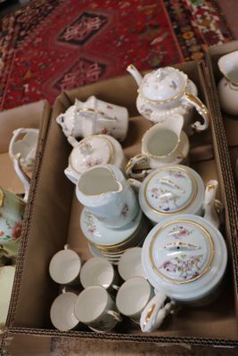 a box full of tea cups and saucers on the floor