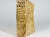 an old book sitting on top of a table next to a white wall