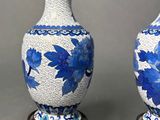pair of blue and white vases sitting on a wooden stand