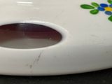 a white vase with a colorful flower design on it