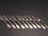 six forks are arranged in a row on a black surface