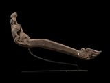un gros plan sur une sculpture représentant une personne allongée sur une surface noire