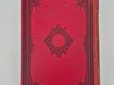 a red book sitting on top of a white surface