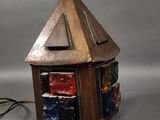 a small lamp that has a small house on top of it