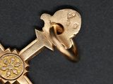 a gold cross with a gold ring on top of it