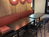 tables and chairs in a restaurant with a wood paneled wall behind them