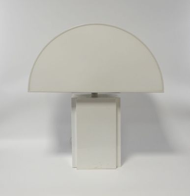 a white table lamp with a white shade on top of it