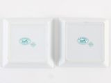 pair of white porcelain dishes with green designs on them