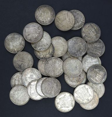 tas de pièces d'argent posées sur une surface noire, sur fond noir