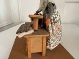 a figurine of a woman sitting on a bench