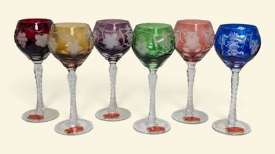 six verres à vin alignés sur une surface blanche
