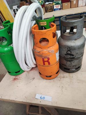 three propane gas cylinders on a table with a hose