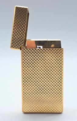 un briquet doré posé sur une surface blanche