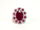 a close up of a ruby and diamond ring on a white background