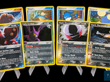 Plusieurs cartes Pokémon sont alignées les unes à côté des autres sur un fond noir.