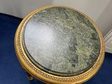 a small table with a marble top on a blue carpet