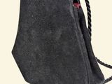 the small black bag is sitting on a white surface