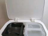 a small refrigerator with a plastic container inside of it