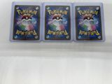 three pokemon cards are sitting on top of a white surface