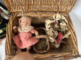 a small doll in a wicker basket with a doll inside of it