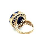 an image of a gold ring with a blue stone in it
