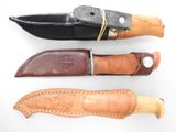 three different types of knifes with leather sheaths on a white surface