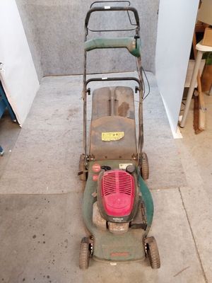 une image d'une tondeuse à gazon garée dans un garage