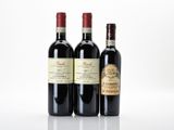 three bottles of wine sitting next to each other on a white surface