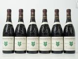 six bouteilles de vin sont alignées sur une table