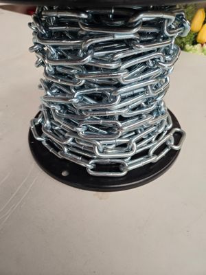 un gros plan d'une bobine sur laquelle sont enroulées des chaînes, posée sur une table